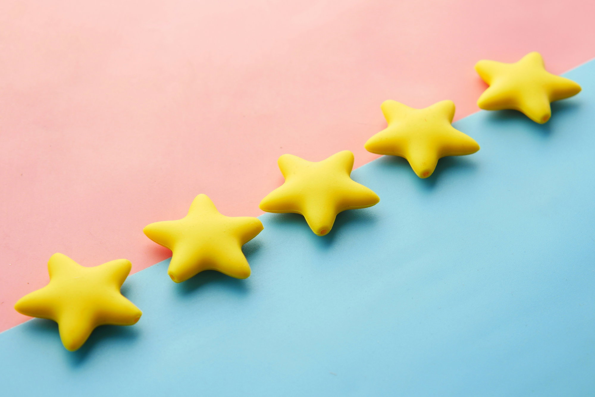 a-row-of-yellow-stars-sitting-on-top-of-a-blue-and-pink-surface.jpg a row of yellow stars sitting on top of a blue and pink surface